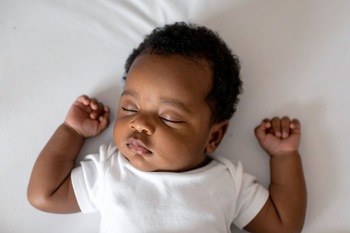 Baby asleep on a firm, clear, safe sleep surface