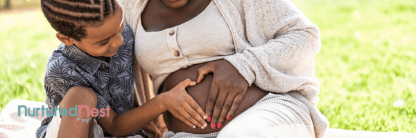 Young child connecting with pregnant parent, hands on baby bump, showing early empathy and sibling bonding