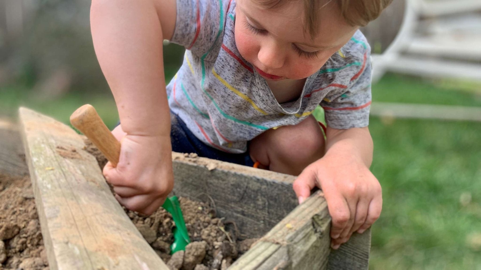 Young child playing outside in dirt