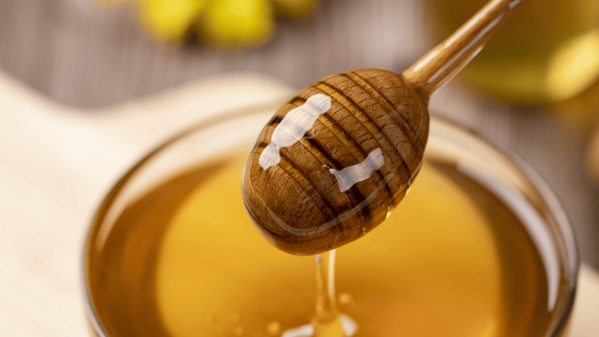Jar of honey with dripping honey dipper—visually appealing but a reminder that honey is unsafe for babies under 12 months due to risk of infant botulism.