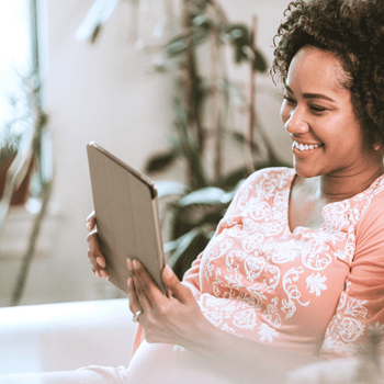 expecting mom watching an online childbirth class on her tablet at home