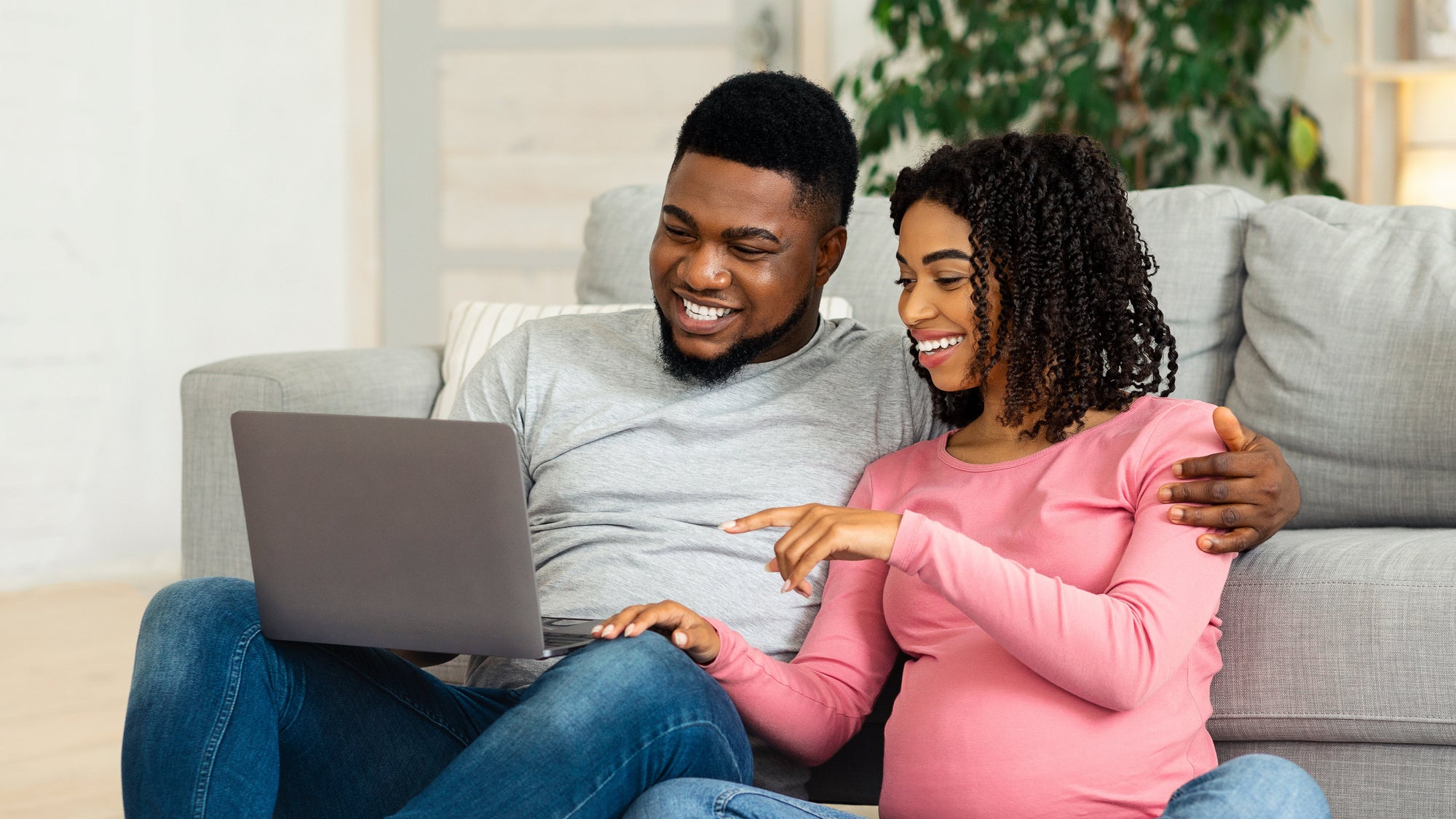 Mom and dad with their cat watching online childbirth class