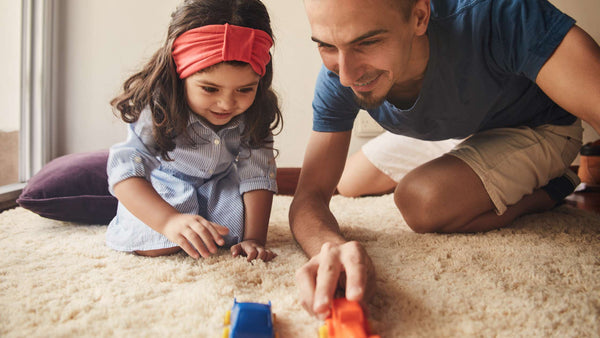parents tickling their young child and laughing